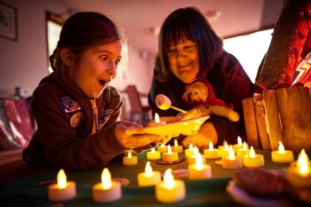 Frankie Fernandez, eight, from 2nd Northenden (St Wilfrid’s) Brownies, with Veronica Armstrong around a camp fire.