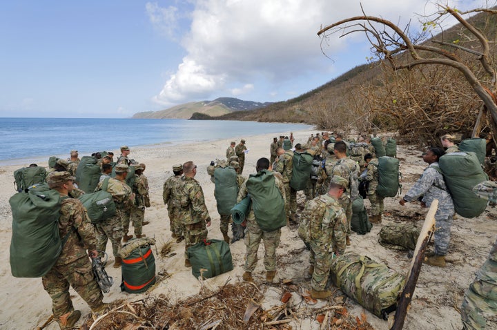 Army soldiers from the 602nd Area Support Medical Company gather on a beach as they await transport on a Navy landing craft while evacuating in advance of Hurricane Maria, in Charlotte Amalie, St. Thomas, U.S. Virgin Islands, Sept.17, 2017.