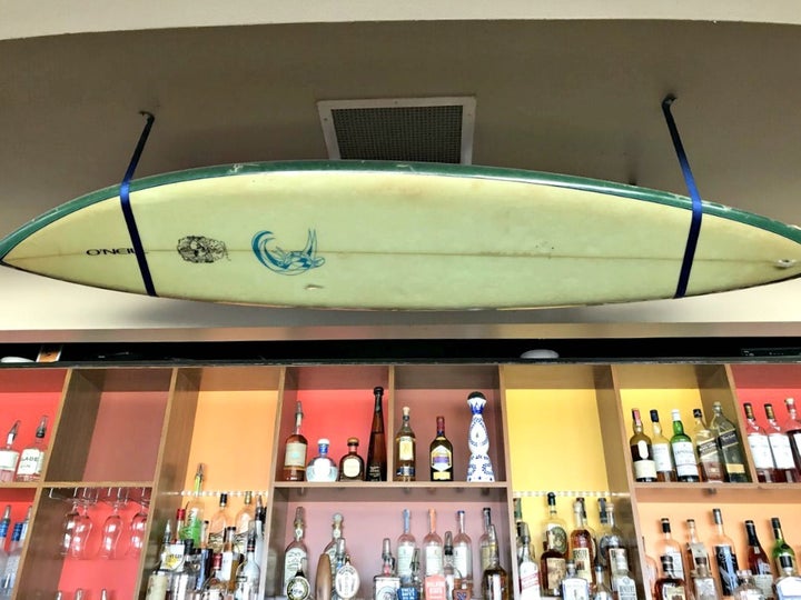 <p>O’Neill surfboard hangs over Jack O’Neill Lounge bar</p>