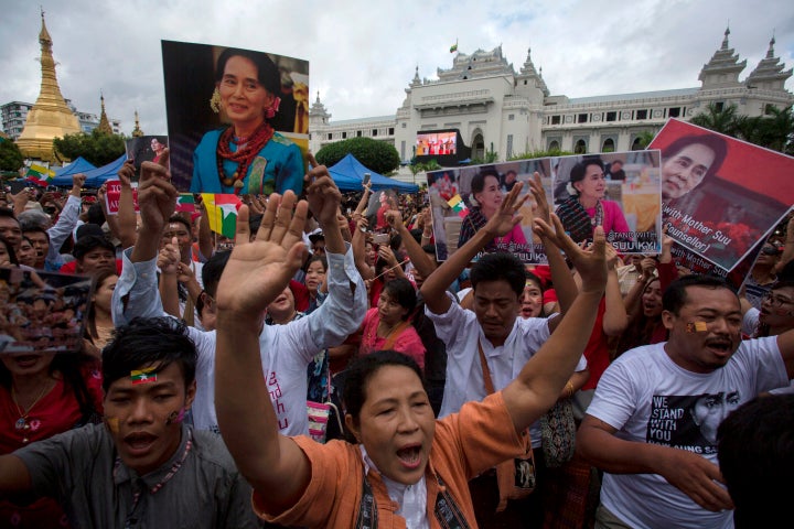 People hold the Myanmar national flag and placards as they attend a public gathering to listen to the live speech of Myanmar'