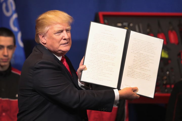 President Donald Trump signs an executive order to try to bring jobs back to American workers and revamp the H-1B visa guest worker program during a visit to the headquarters of tool manufacturer Snap-On on April 18, 2017 in Kenosha, Wisconsin.