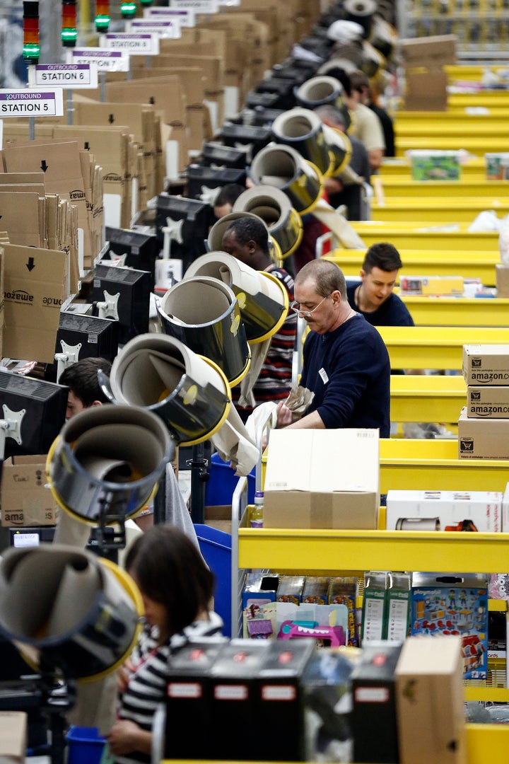 Amazon staff work the packing stations at Rugeley in 2013. After costs for a special bus service, some workers are left with less than the minimum wage