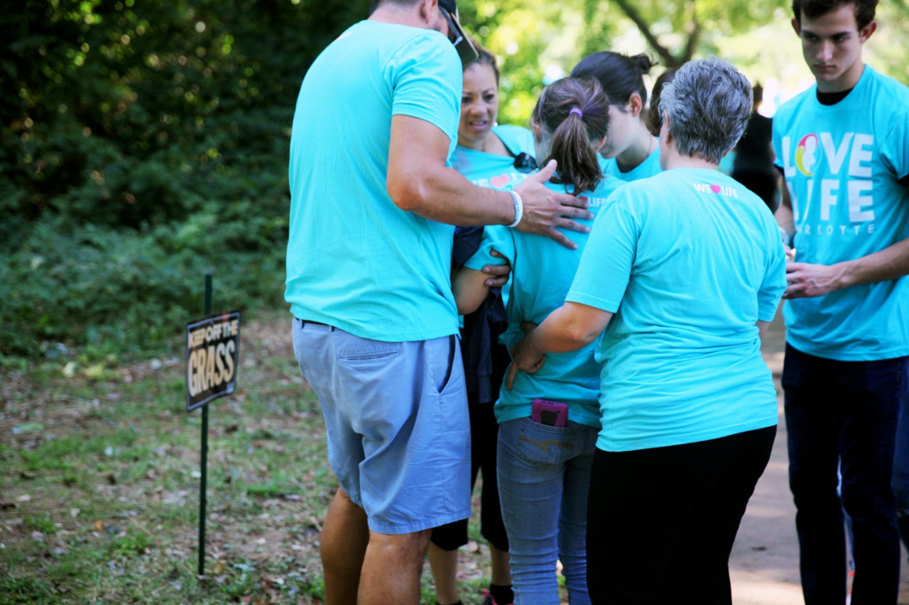 A young member of Love Life Charlotte tries to stand up after suffering dehydration and heat exhaustion on Saturday.