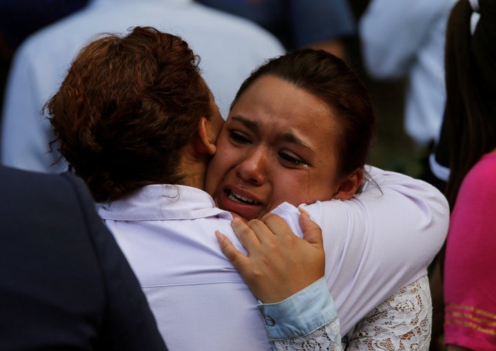 A woman reacts outside a collapsed building after an earthquake in Mexico City