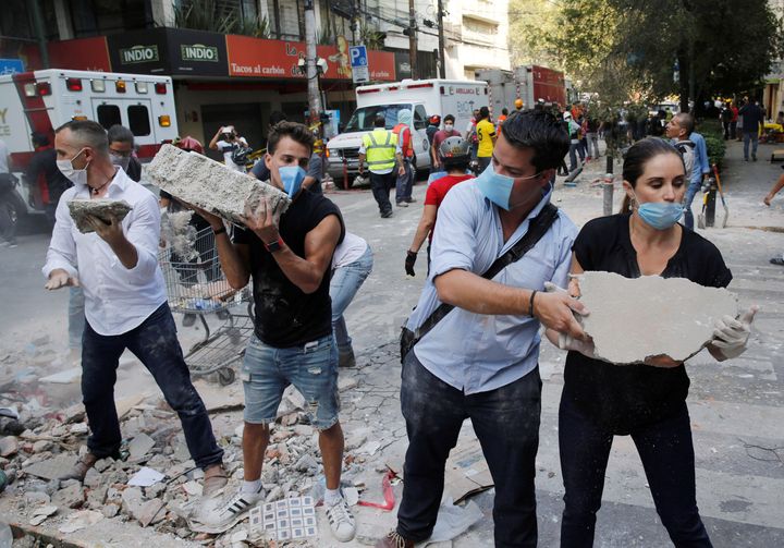 <strong>People remove debris outside a collapsed building after an earthquake in Mexico City</strong>