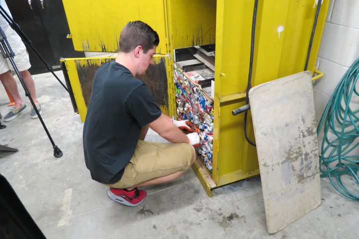 <p>A student prepares the aliminum can bailer for compacting. </p>