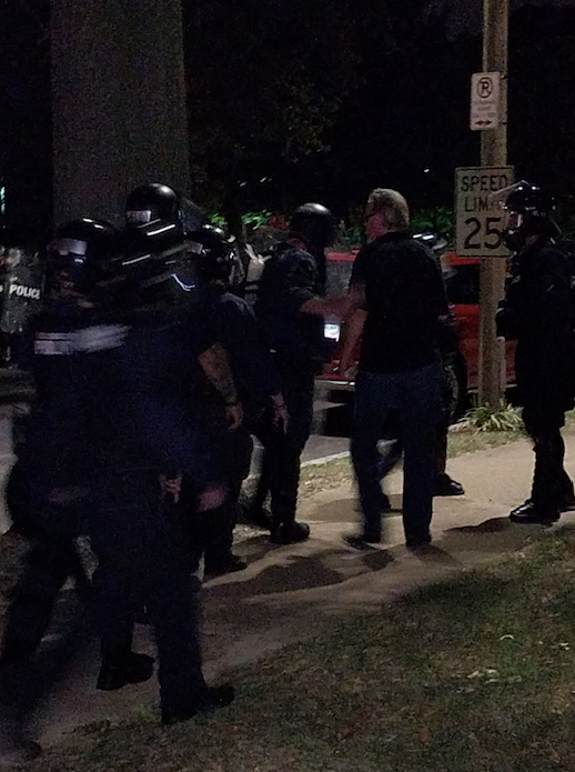 Rev. Gary James speaks to police in St. Louis Friday night.