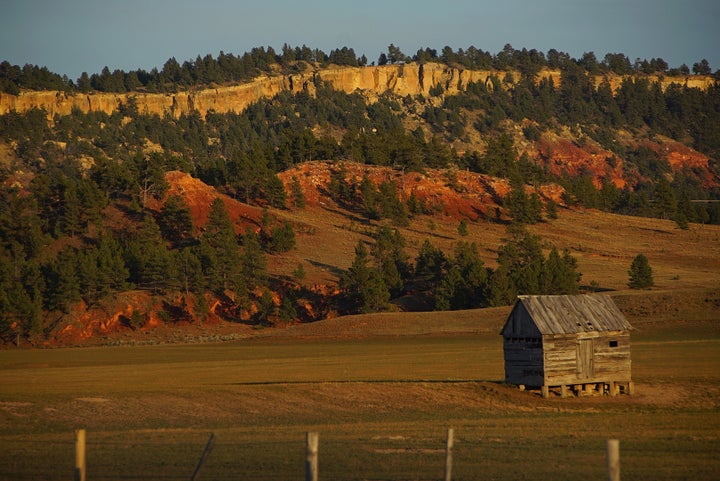 <p>A small shed on a free range outside of Hulett Wyoming. This image was taken as the Sun was getting low in the West, the ‘sweet light’ time. Visible are the red Spearfish Formation sedimentary rock at bottom, the brown Stockade Beaver Shale above it, and finally the Hulett Sandstone at the top that is yellowish tan. The colors are dramatic especially at sunrise and sunset. </p>