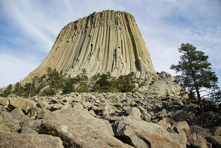 <p>Devils Tower seen from the base. The many rocks and boulders, some house sized, form deep crevasses in which rattlesnakes and other animals seek refuge from the hot Sun. At least one rattler was seen this day near this spot. </p>