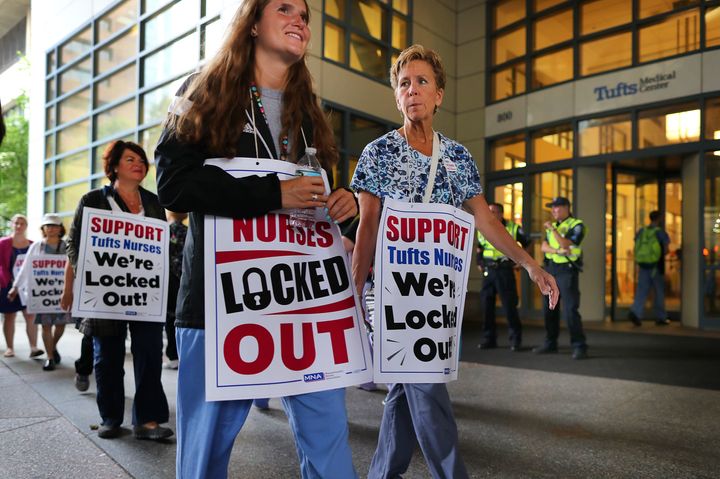Tufts Medical Center nurses picket in Boston on July 13 after being locked out after a 24-hour strike. One of the sources of stress nurses report is not being included in the decision-making process at health facilities.