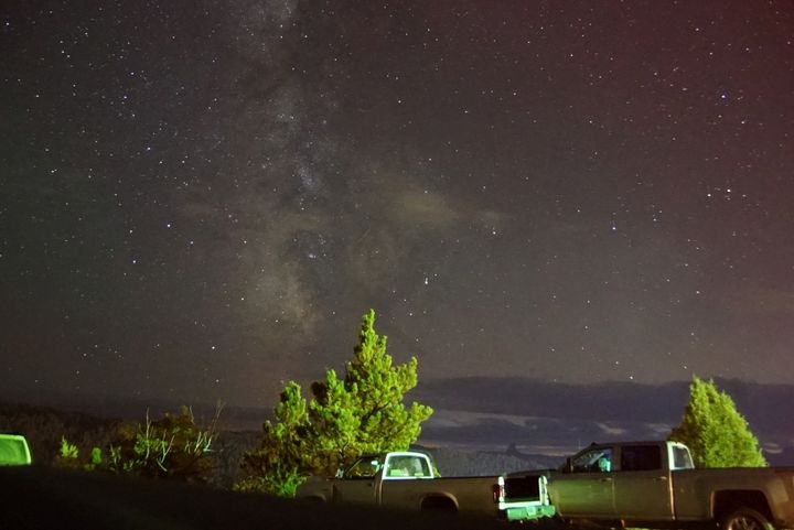 <p>Milky Way with some cloudy interlopers inHulett. Note that Devil’s Tower, 9 miles away is visible in the distance just above the front of the hood on the right hand truck. </p>