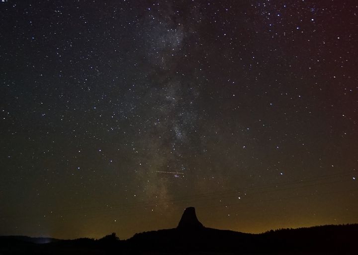 <p>Devil’s Tower rises like a silent sentinel above the surrounding Wyoming wilderness. The Milky Way descends through it... </p>