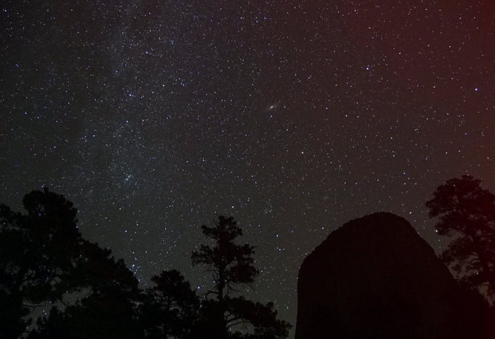 <p>The Andromeda Galaxy can be seen just above center in this image of the northeastern Milky Way as seen from the base of Devil’s Tower. The red glow on the right is due to an intrinsic characteristic of fast cameras called called amplifier glow. During final processing that color will be removed from the image. </p>