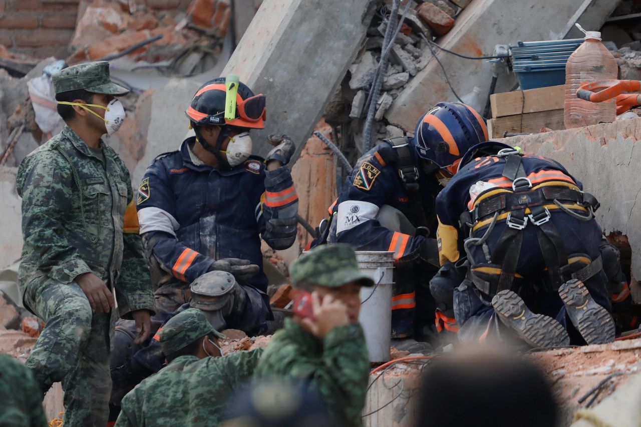Rescue workers search for students through the rubble after an earthquake at Enrique Rebsamen school in Mexico City