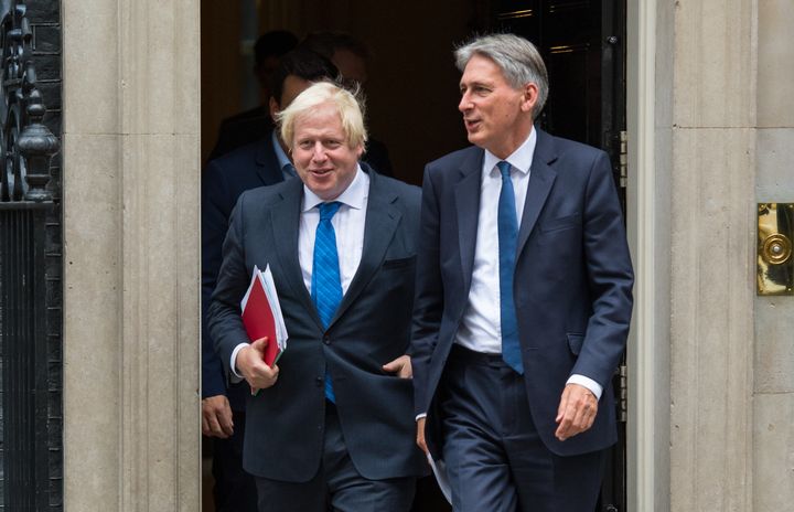 Boris Johnson (left) and Chancellor Philip Hammond leave 10 Downing Street side by side in a show of unity.