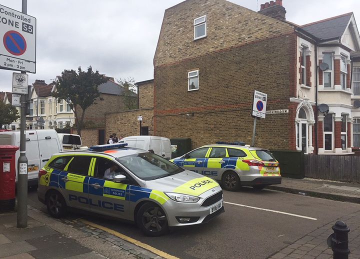 Police at the scene in Southfields, southwest London, where a man and woman have been arrested on suspicion of murder after a badly burned body was found in a garden.