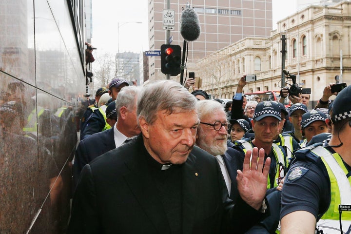 Cardinal George Pell walks with a heavy police guard from the Melbourne Magistrates' Court on July 26, 2017. Pell, a high-ranking Vatican official, is facing charges of “historical sexual assault offenses.”