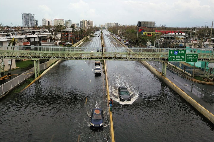 Cars drive through a flooded road in the aftermath of Hurricane Maria in San Juan on Sept. 21, 2017.