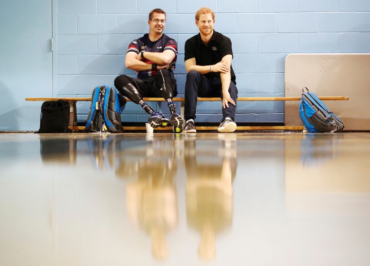 Prince Harry sits with one of the athletes at the Toronto Pan Am Sports Centre.