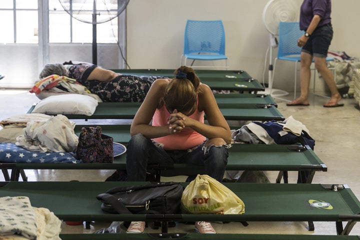 A resident sits inside a shelter in Isabela, Puerto Rico, after being evacuated from her home in the wake of Hurricane Maria.