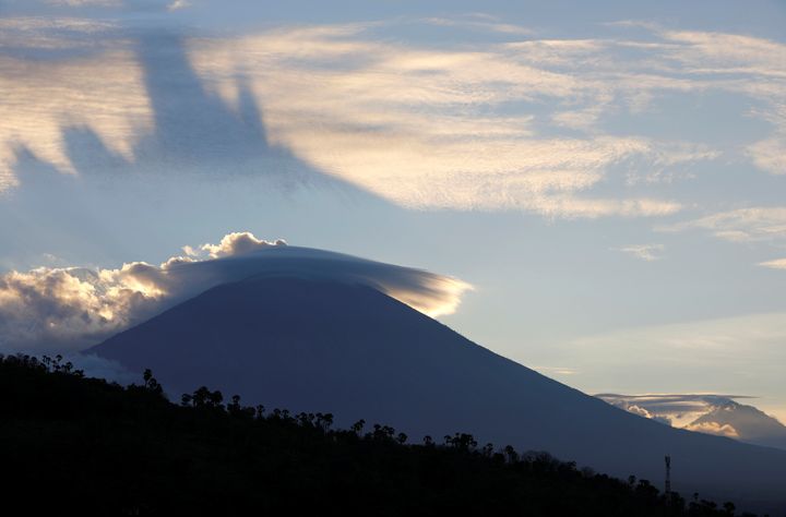 The sun sets behind Mount Agung, a volcano on the highest alert level on the Indonesian island of Bali 