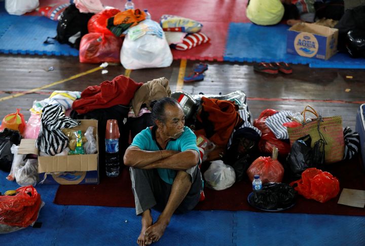 A man rests at a temporary evacuation center for people living near Mount Agung
