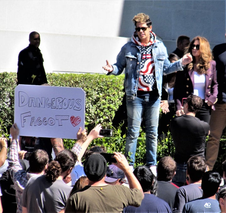 Milo Yiannopoulos, appearing on the Cal campus around noon on September 24th. (To the uninformed, this photo might look like poor Milo was being besieged by bigots calling him the f-word. But the reality is that "Dangerous Faggot" is what he calls himself and the sign in the crowd was held by a fan. [photo credit: Paul Iorio] 