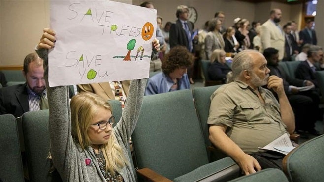 Jayden Malone holds up a sign during a hearing at the Texas Capitol in July on a bill that would have given private property