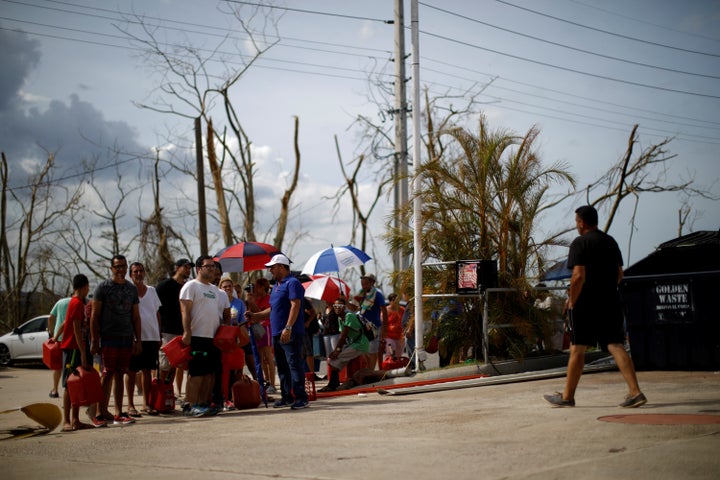 People queue to fill containers with gasoline at a gas station after the area was hit by Hurricane Maria in Toa Baja, Puerto Rico.