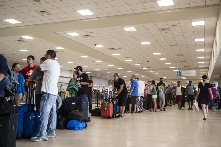 Travelers stand in line at Luis Muoz Marn International Airport in San Juan, Puerto Rico, on Monday.