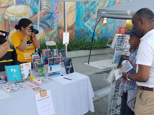 Tsehai Publishers Graphic Designer and Photographer Sara Martinez photographs publisher Elias Wondimu with aspiring author Christian Wagari Howell with his proposed book, “My Cousin George”