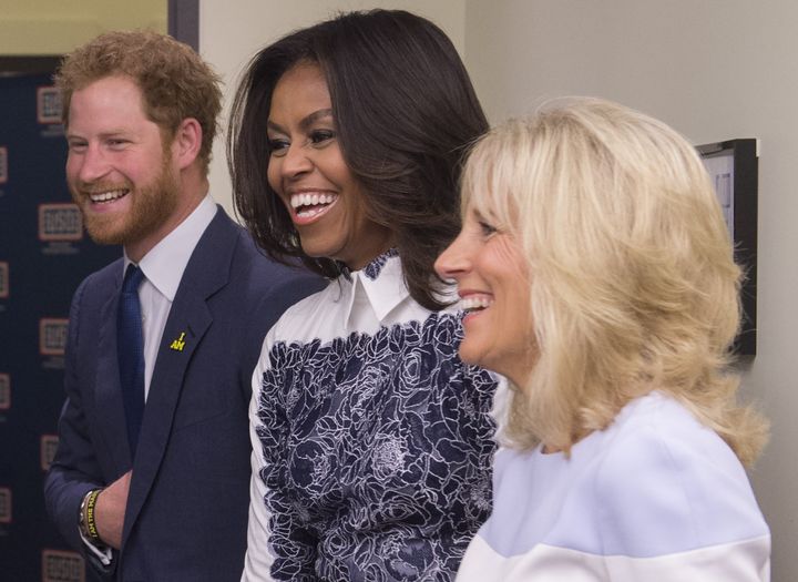 Holding his stomach Wwith Michelle Obama and Jill Biden at the Invictus Games in 2015.