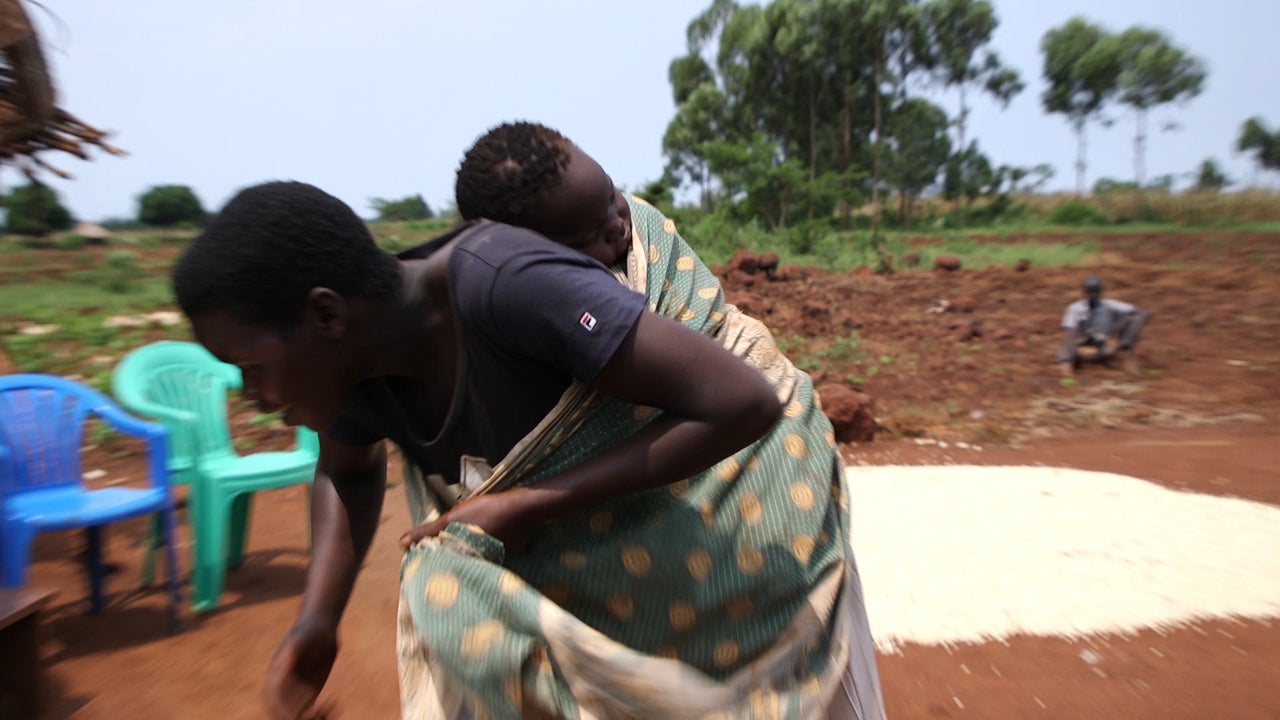 Janet Atwani taking her child to dig.