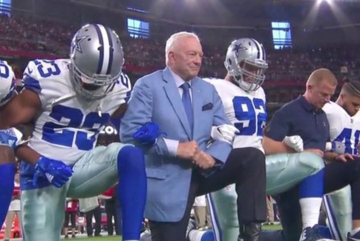 Dallas Cowboys owner, Jerry Jones, kneels with head coach, Jason Garrett, and players in a show of unity.