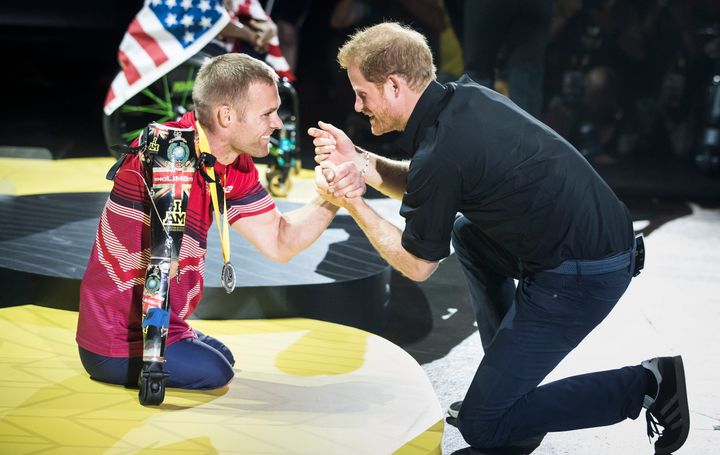 Prince Harry presents a medal to a veteran at the Invictus Games.