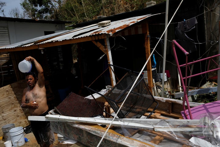 A man showers with water from a well on a Canovanas street on Sept. 26.