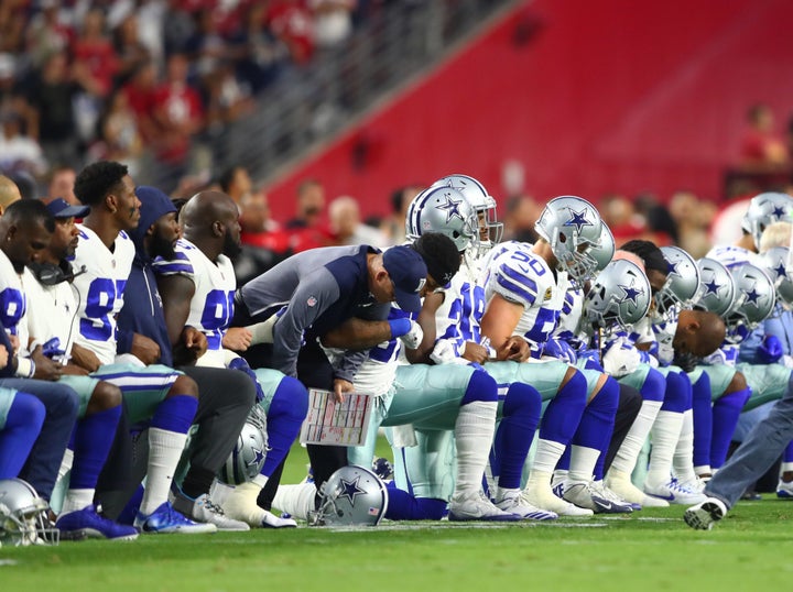 Sept. 25, 2017; Glendale, Ariz., Dallas Cowboys players kneel together with their arms locked prior to the game against the Arizona Cardinals at University of Phoenix Stadium.