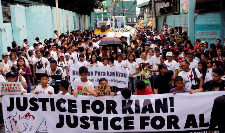 Mourners display a streamer during a funeral march for Kian delos Santos, a 17-year-old student who was killed in Caloocan, Philippines, on Aug. 26.