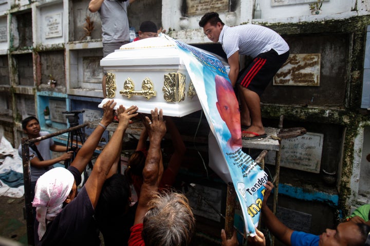 The body of slain teenager Reynaldo De Guzman is laid to rest at a cemetery during funeral rites in suburban Pasig City, east