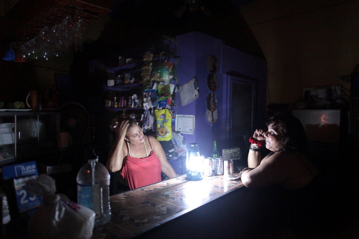 Flor Dalisa Contreras, left, talks with Virginia Rivas at a coffee shop during a power outage in San Juan, Puerto Rico, last week.