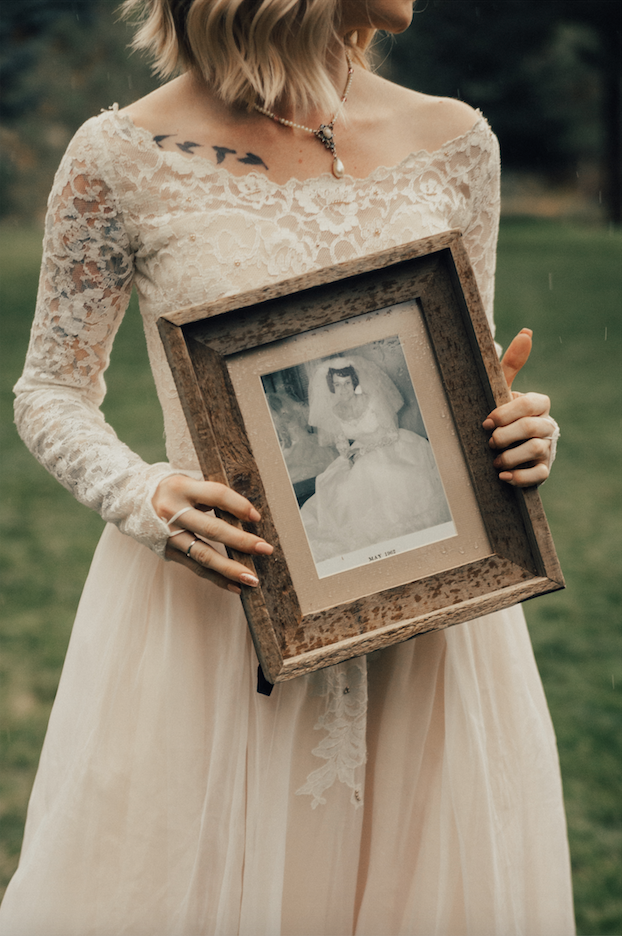 The bride held a framed photo of her grandma in the same dress. 