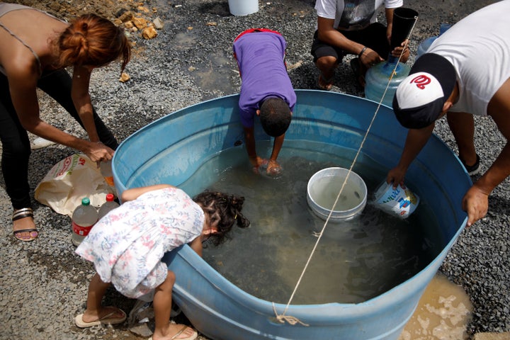 People fill containers with water in an area hit by Hurricane Maria in Canovanas, Puerto Rico, on Tuesday.