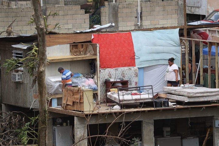 Jose Bernard and his daughter Yolymar salvage what they can from their home in Corozal, Puerto Rico, on Wednesday.