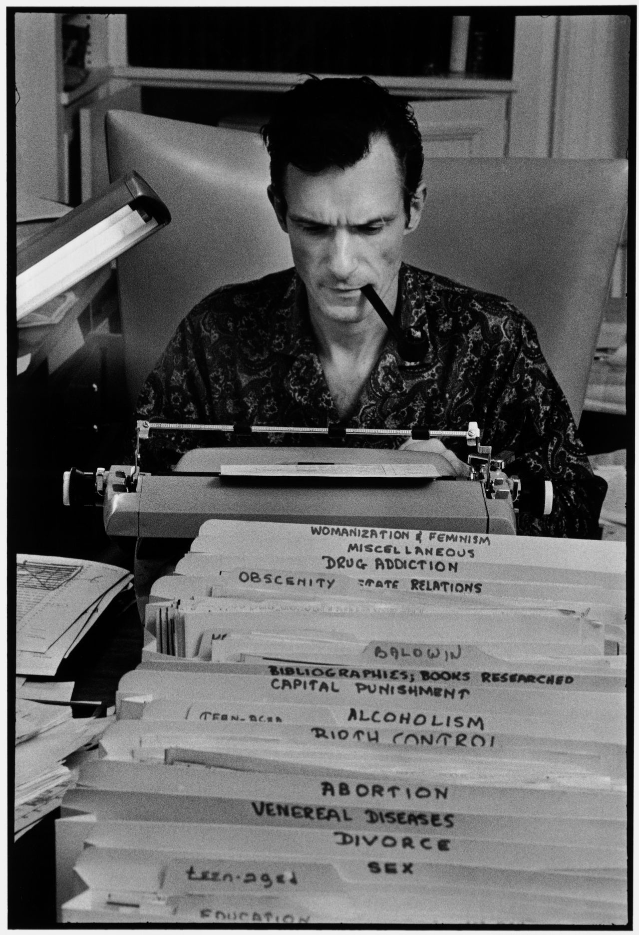 Burt Glinn, "Playboy founder Hugh Hefner typing at his desk in his mansion," Chicago, IL, USA, 1966