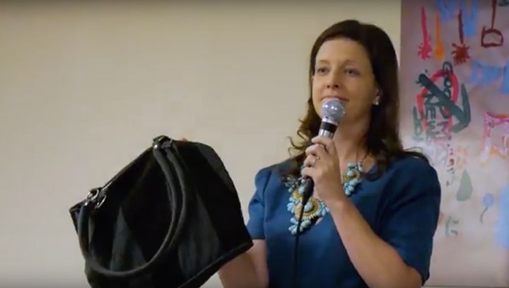 Katy Gaul-Stigge, Goodwill NYNJ CEO and President, holds up the bag that was found containing the money.