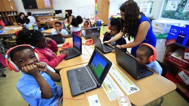 Teacher Jillian Martin helps her class with interactive math problems in a Washington, D.C., elementary school. Some states are experimenting with online “micro credentials” for teacher professional development, hoping the mini-courses will provide skills that are relevant in the classroom.