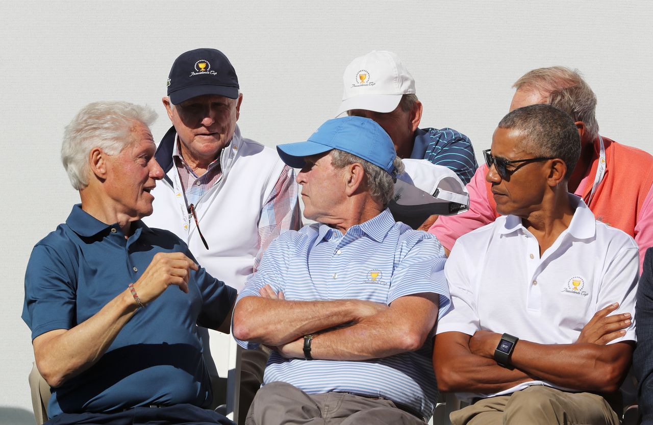 As Clinton chats, Bush and Obama are among those listening.