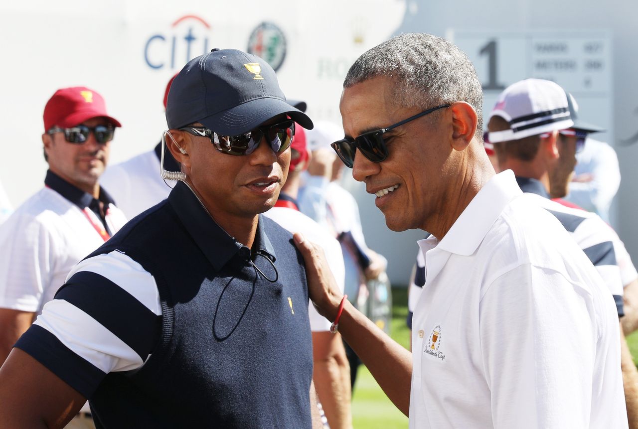 Tiger Woods, a captain's assistant for the U.S. team, talks with Obama.