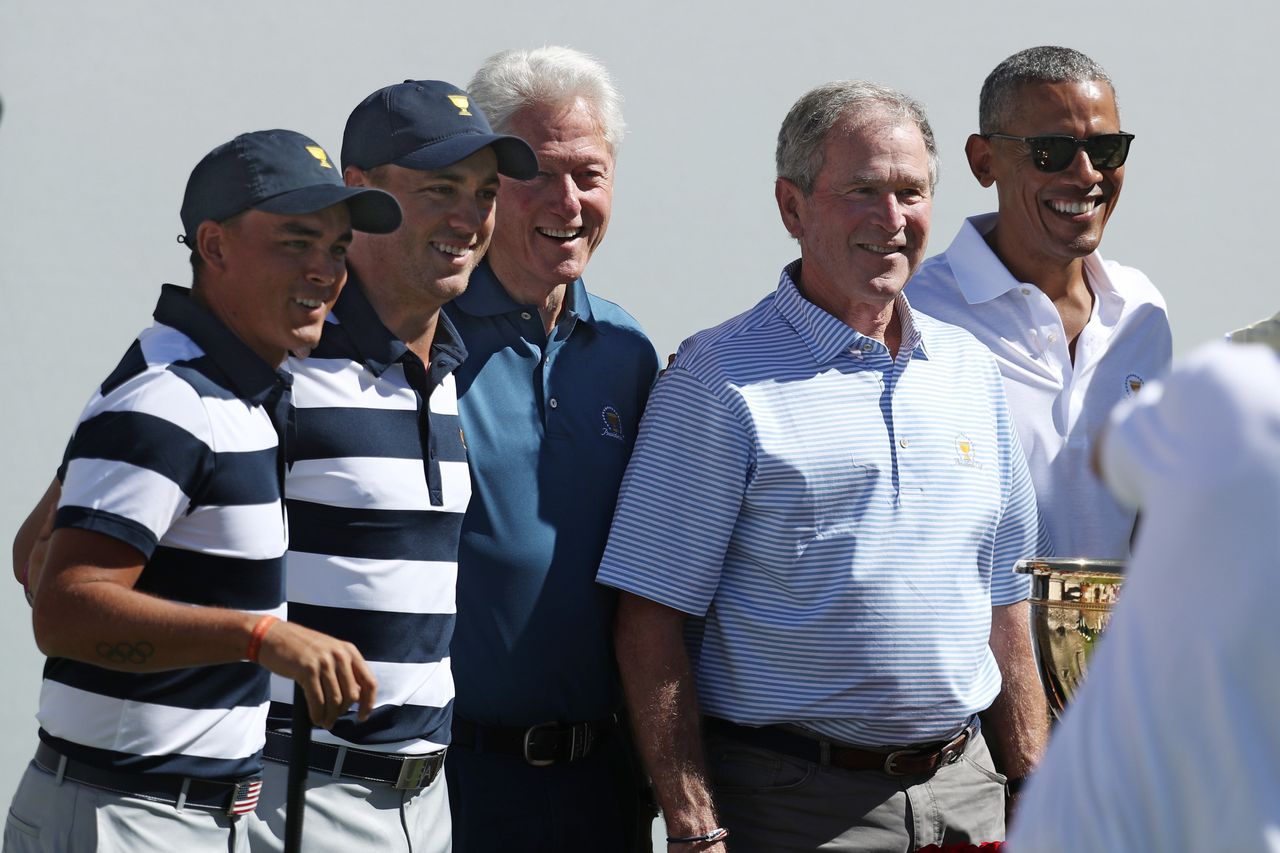 Golfers Rickie Fowler and Justin Thomas of the U.S. team pose for a photo with the three ex-presidents.