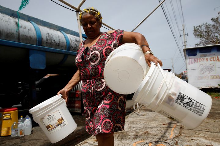 Post-Hurricane Maria, a woman carries buckets to be filled with water from a tank truck in Canovanas, Puerto Rico, on Sept. 26, 2017.